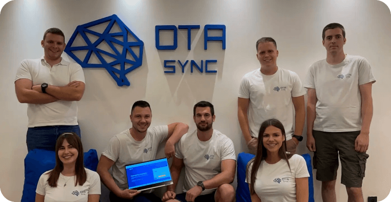 Group posing with OTA Sync logo.