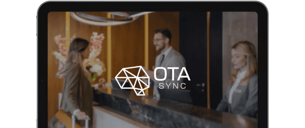 A person with a suitcase is checking in at a hotels front desk where two staff members are assisting. The logo OTA Sync is prominently displayed over the scene.